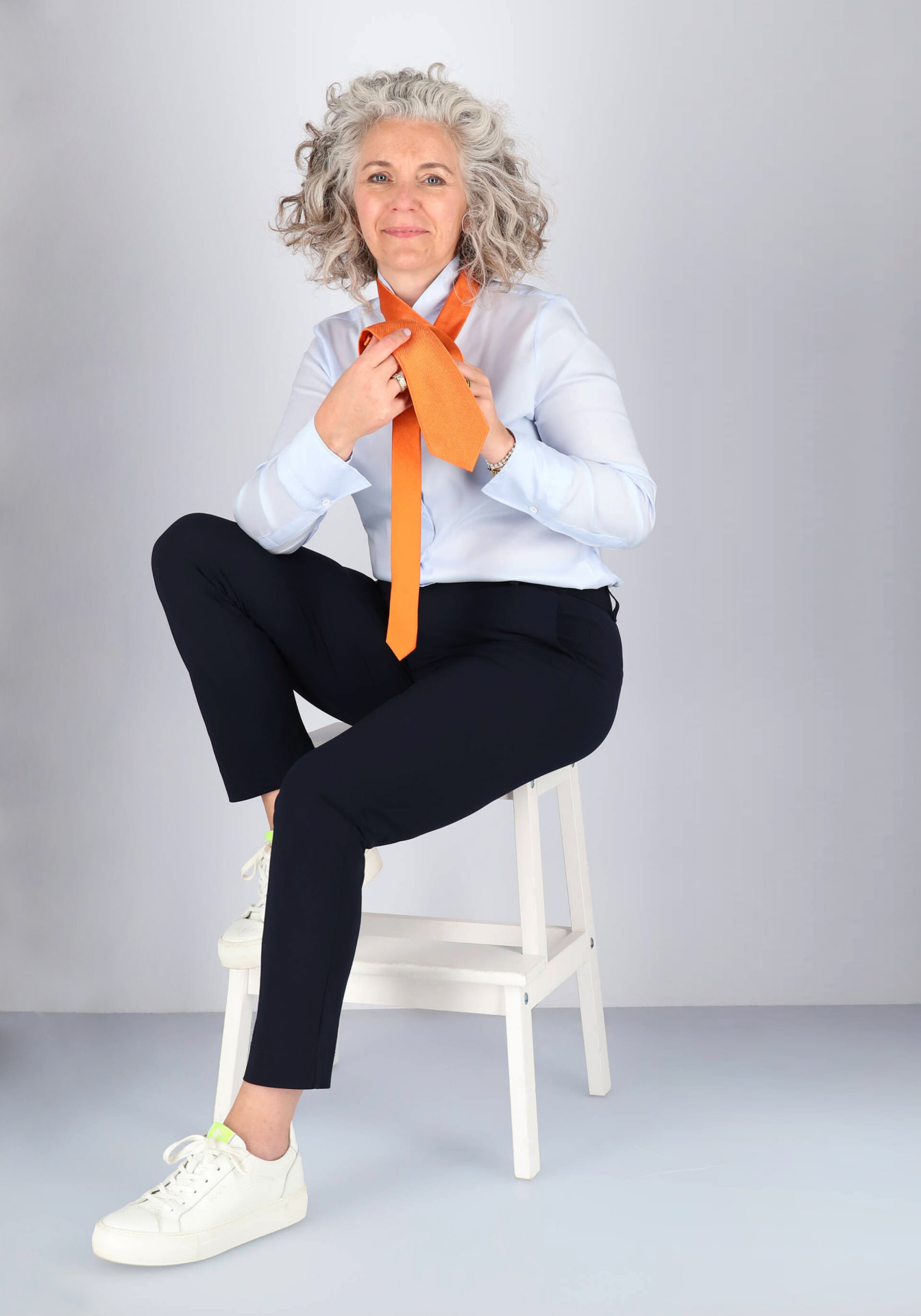 Astrid, stijliste van HemdVoorHem.nl, in lichtblauwe blouse met oranje stropdas